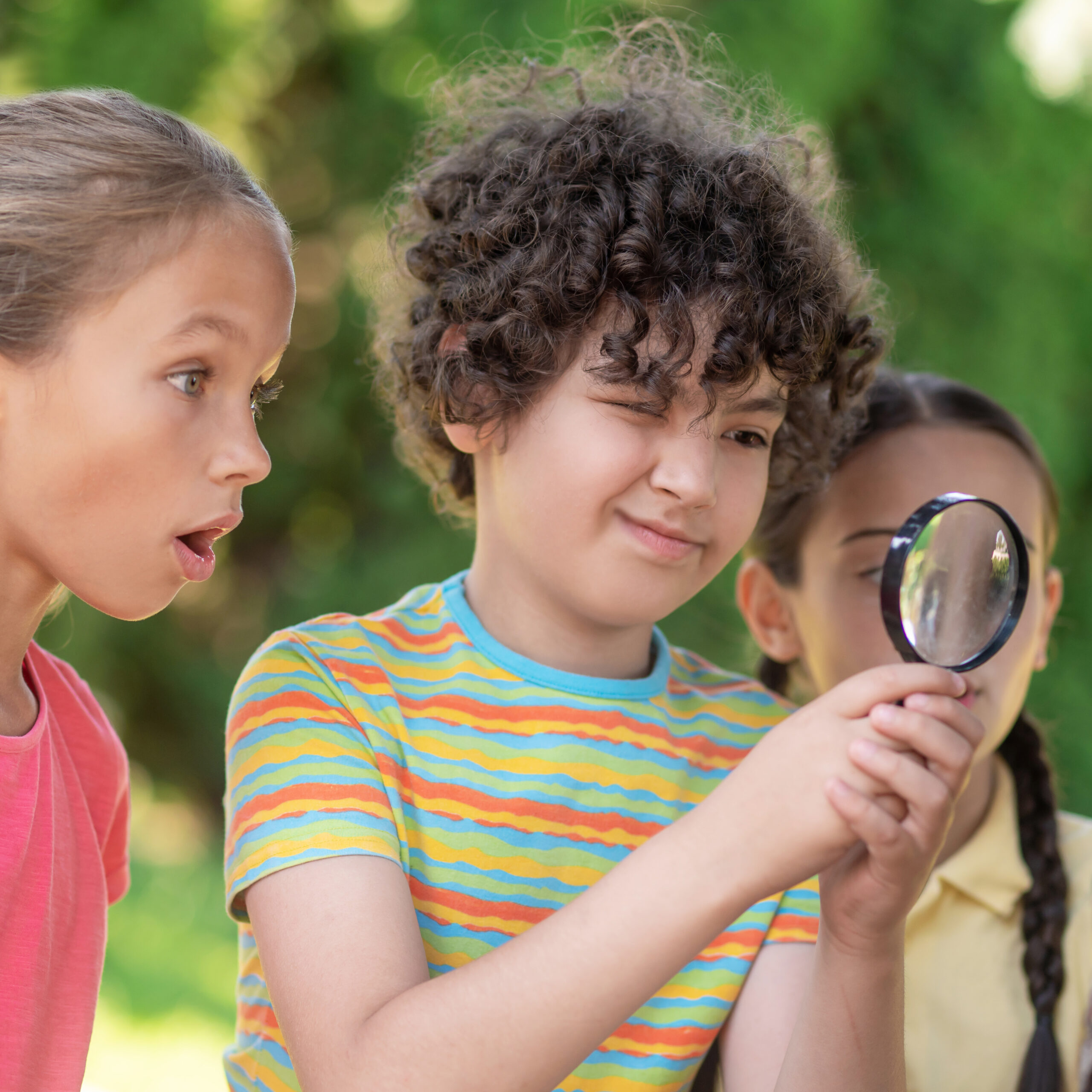 Kids looking through a magnifying glass