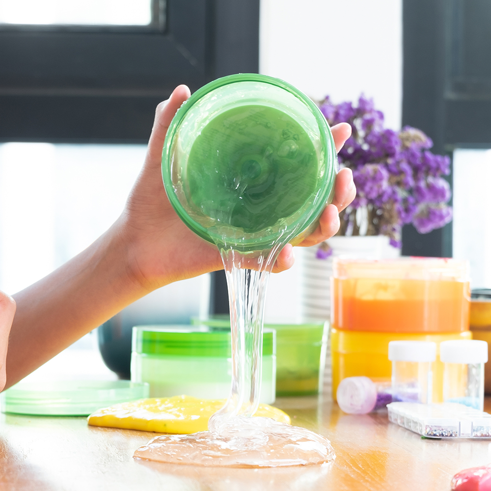 Hand pouring clear slime