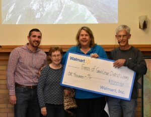 Friends of Library holding donation check from Walmart