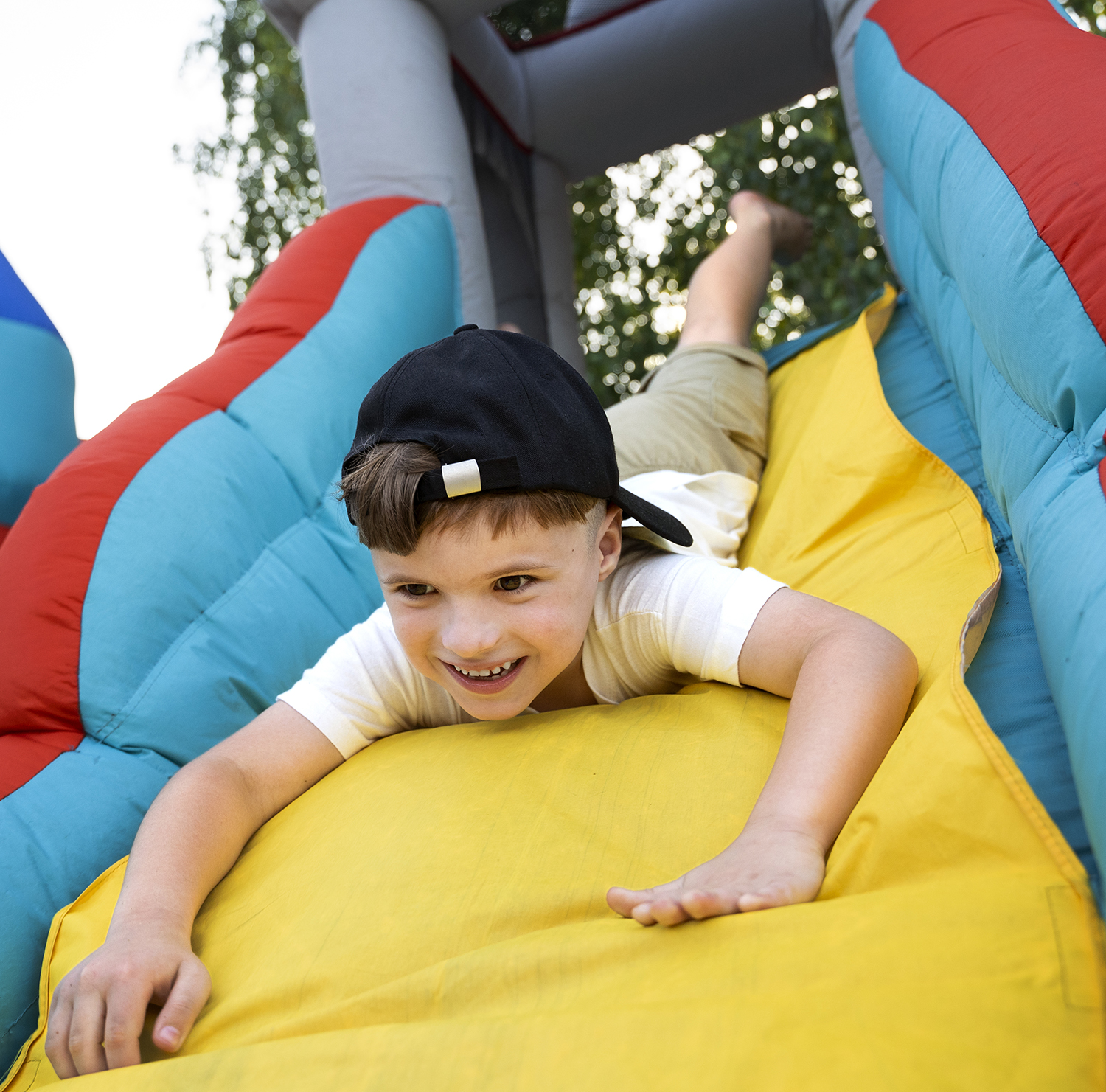 Boy sliding down a bouncy house slide