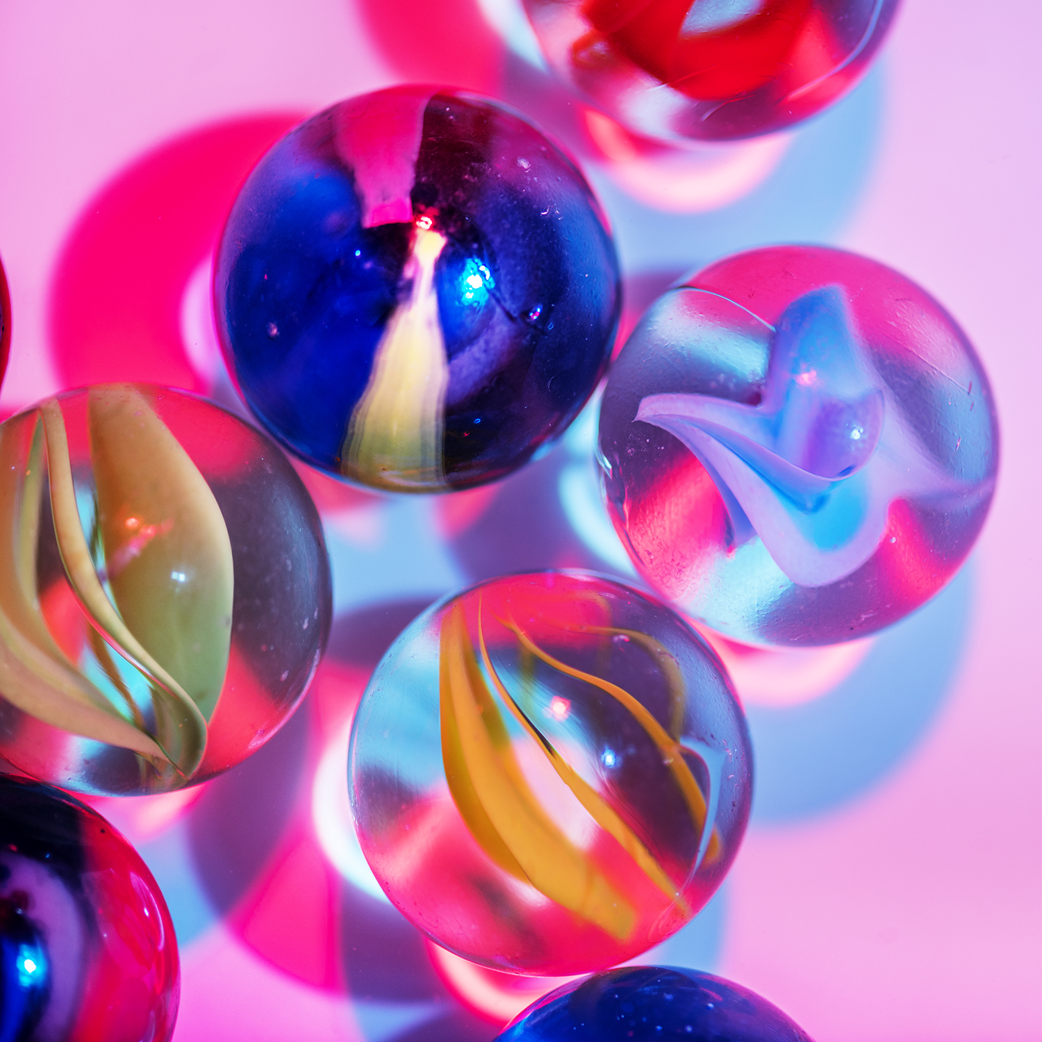 Colorful marbles on a pink surface