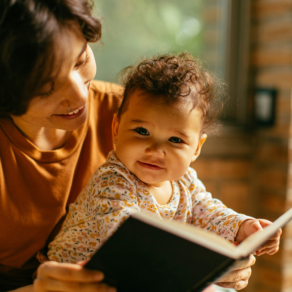 Baby and caregiver with a book