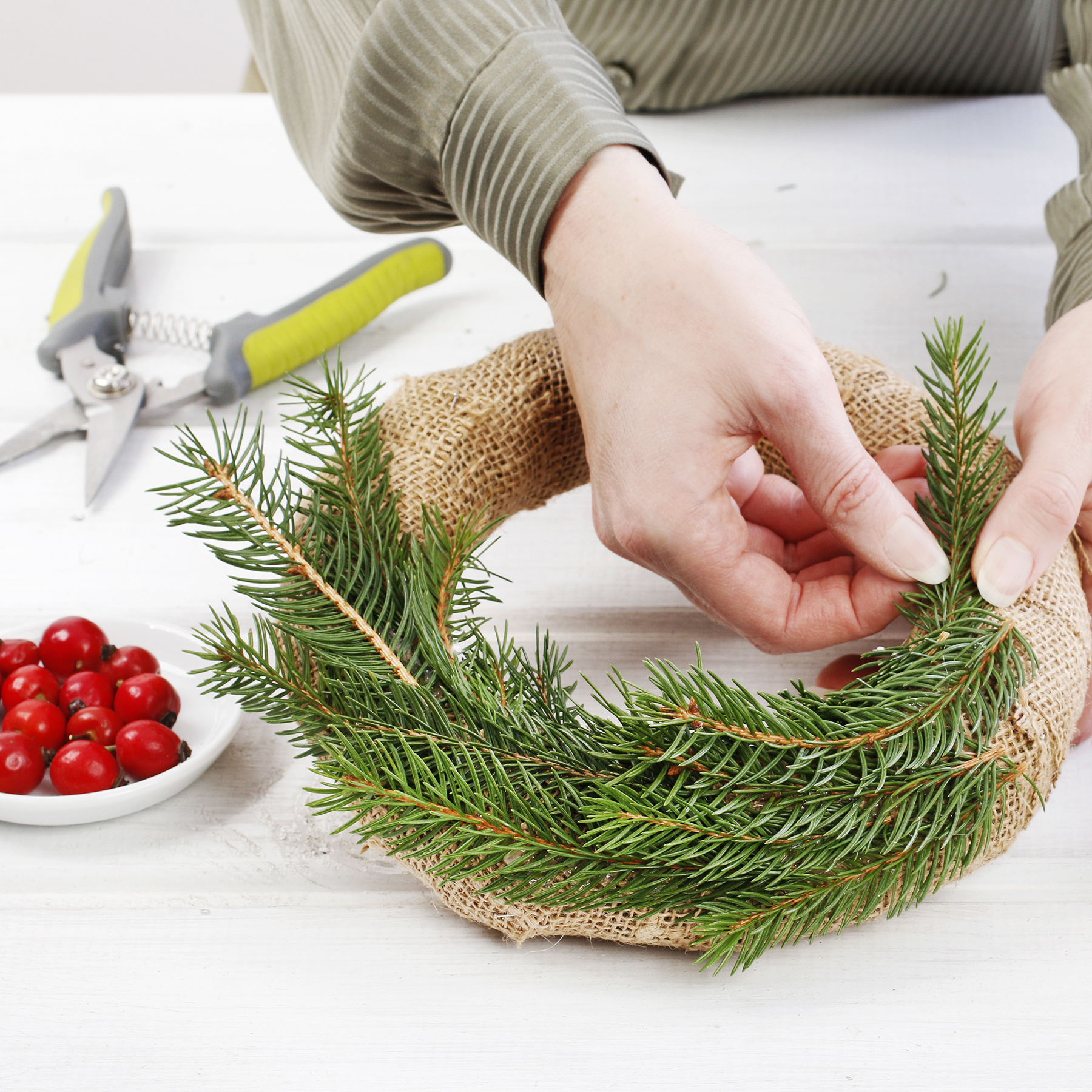 Woman shows how to make classic Christmas door wreath