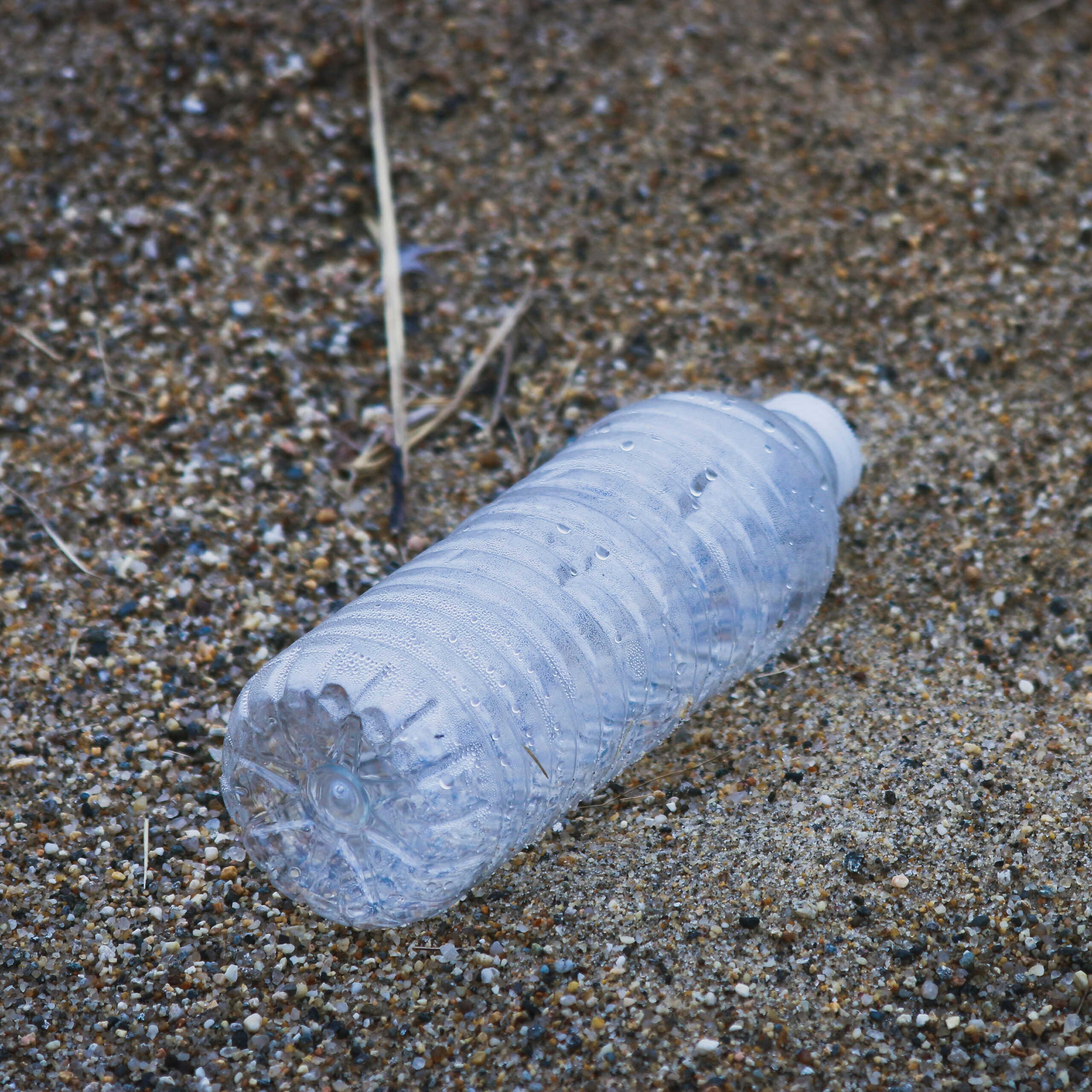 Empty water bottle on sand