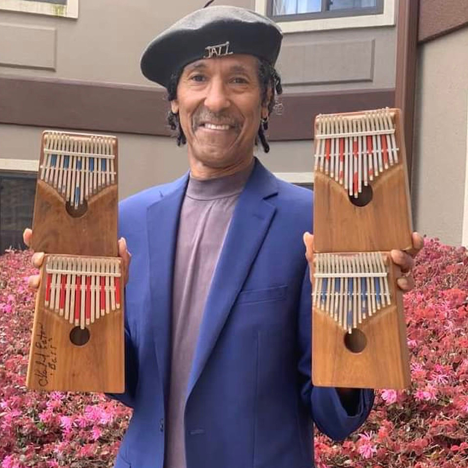 Carl Winters AKA "The Kalimba King" holding 4 kalimbas