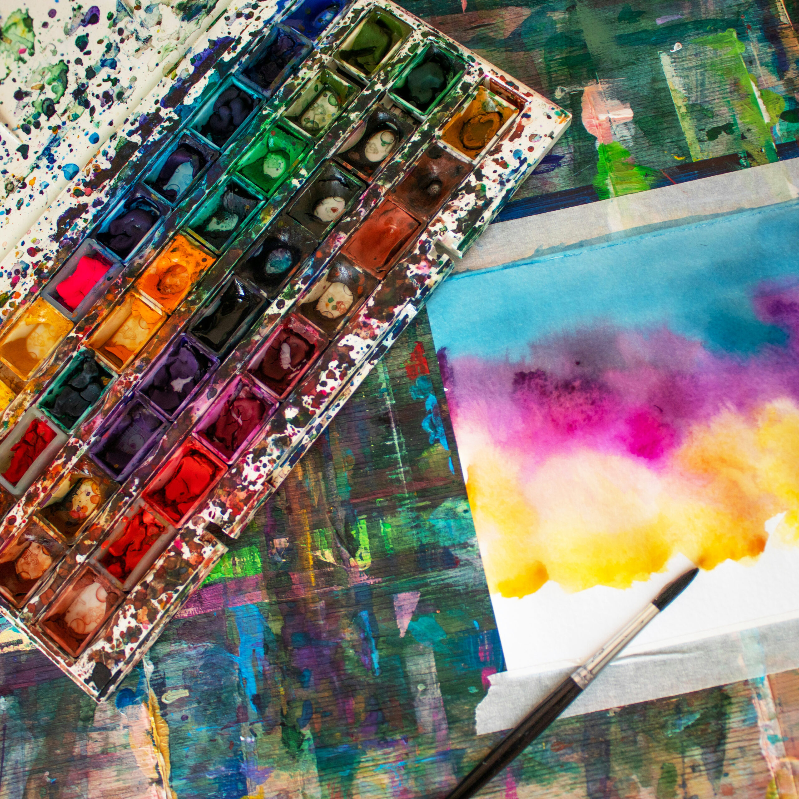 Watercolor paints next to a watercolor painting