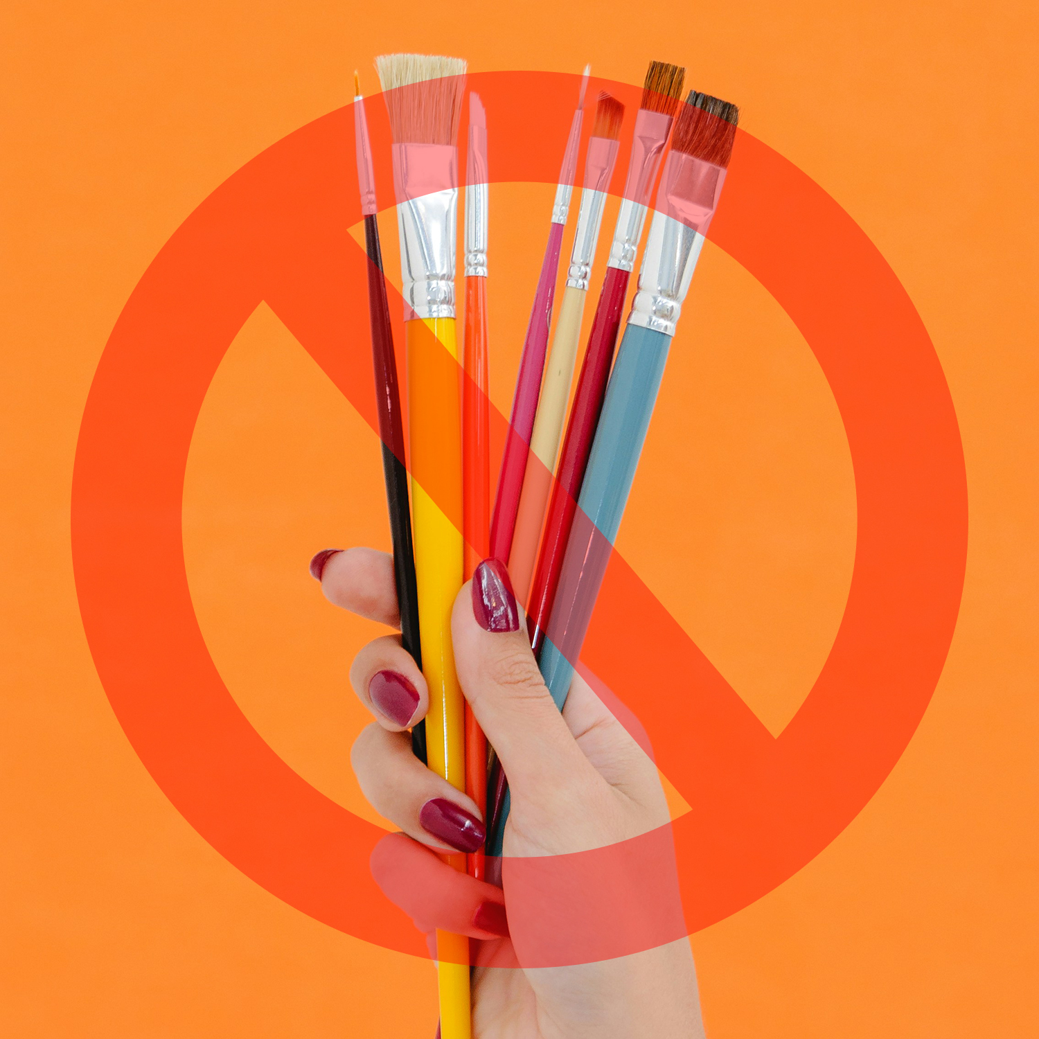 Hand holding paintbrushes with no symbol across it