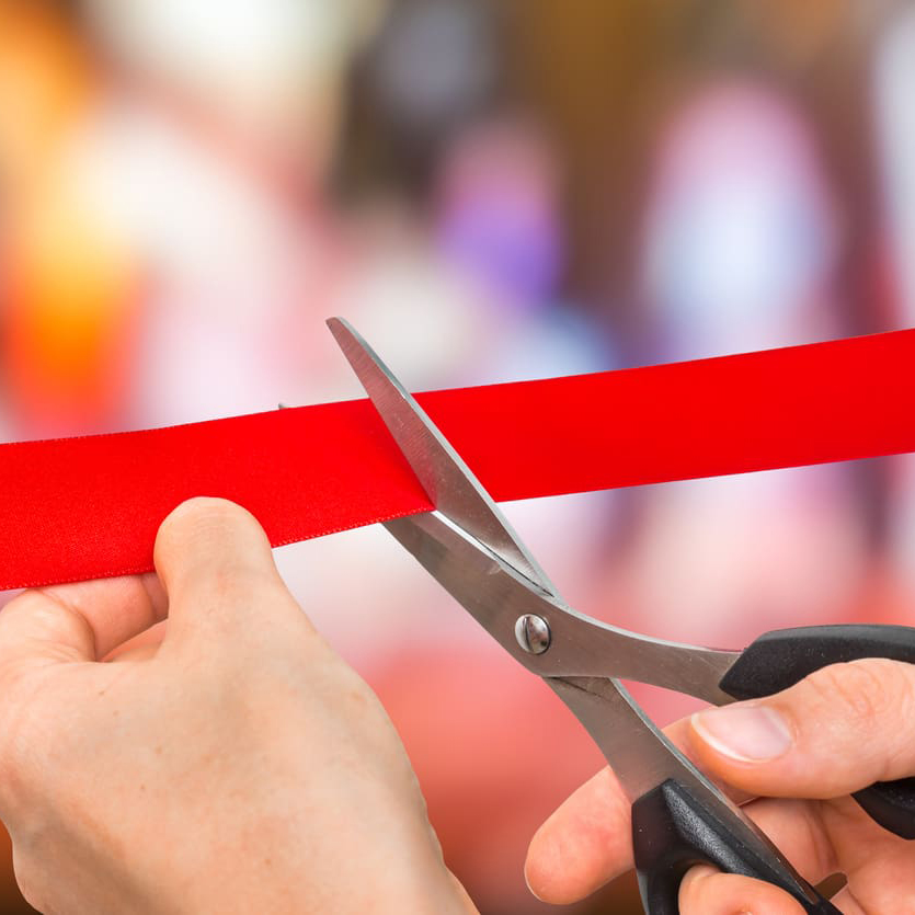 Hands cutting a ribbon