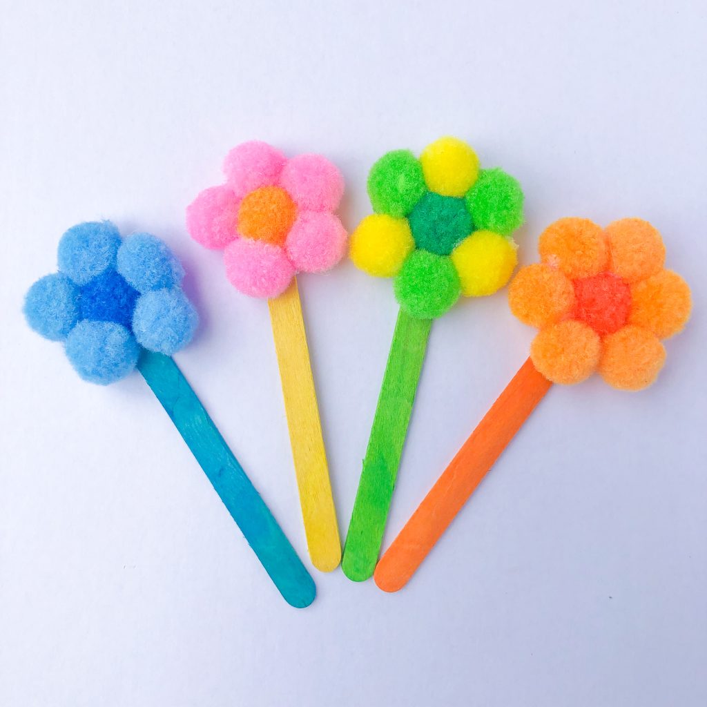 Pom-poms glued in a flower shape to popsicle sticks