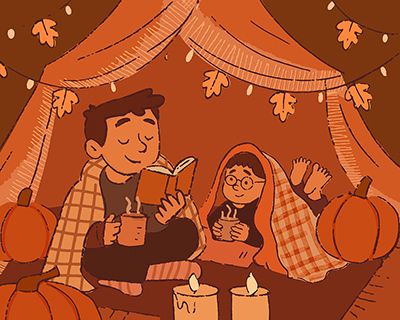 Dad and son reading together under blankets with fall decor