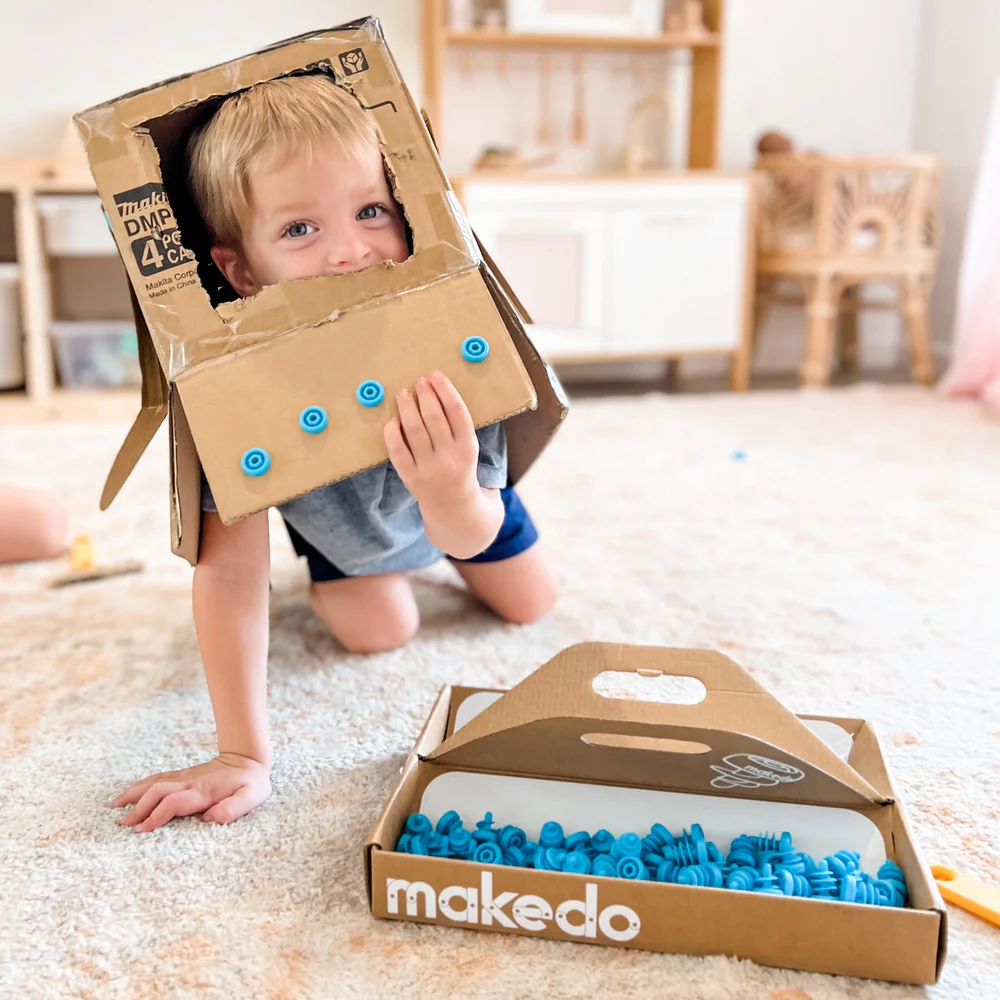 Kid wearing a cardboard space helmet