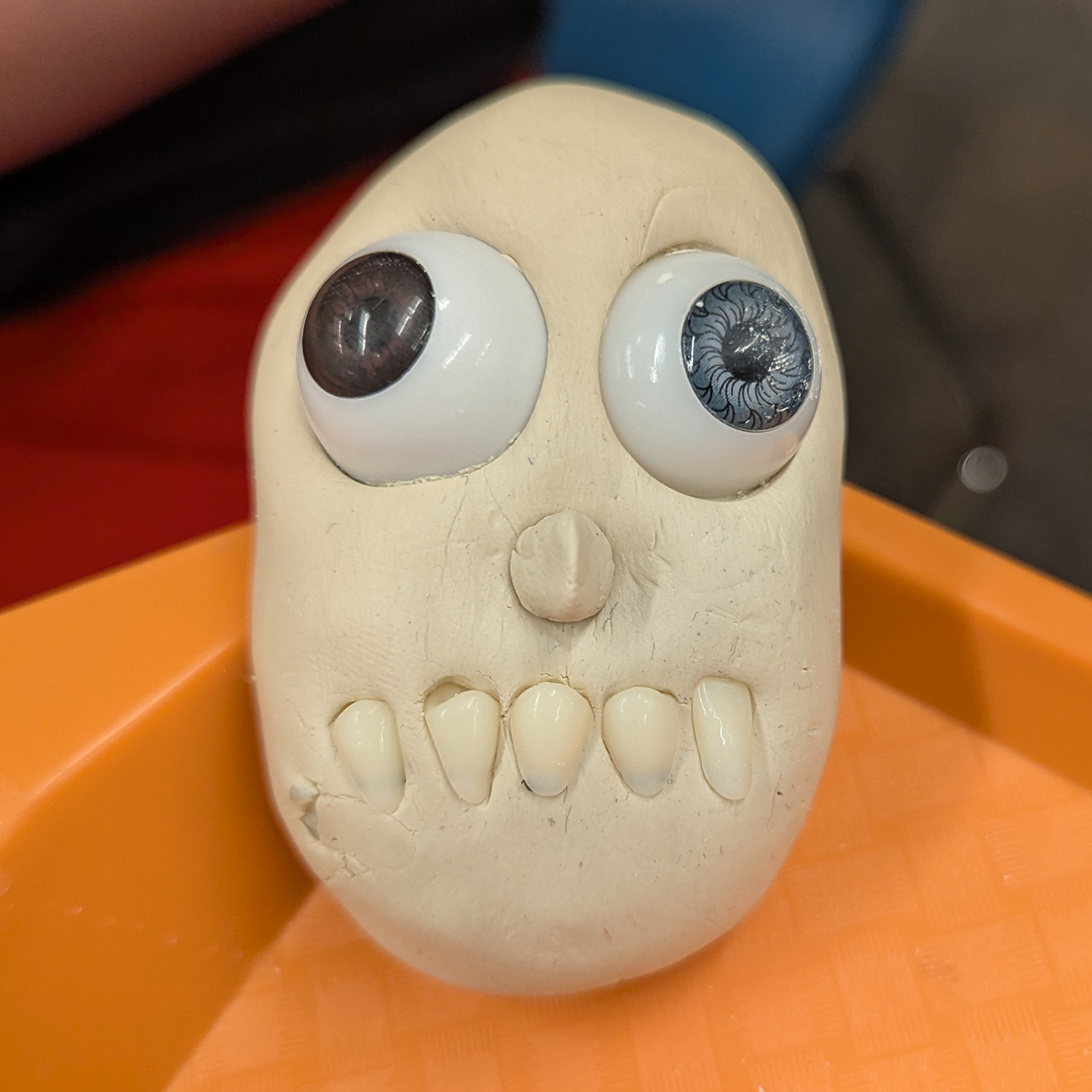 Creepy clay creation with realistic eyeballs and teeth