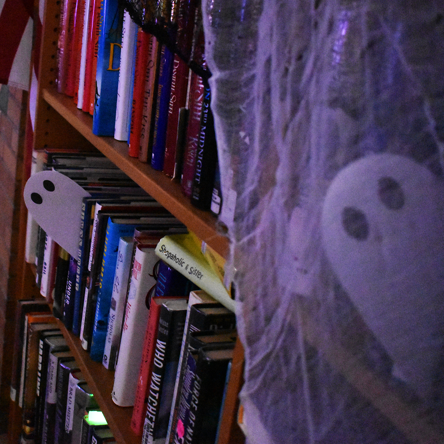 Paper ghosts in a shelf of books