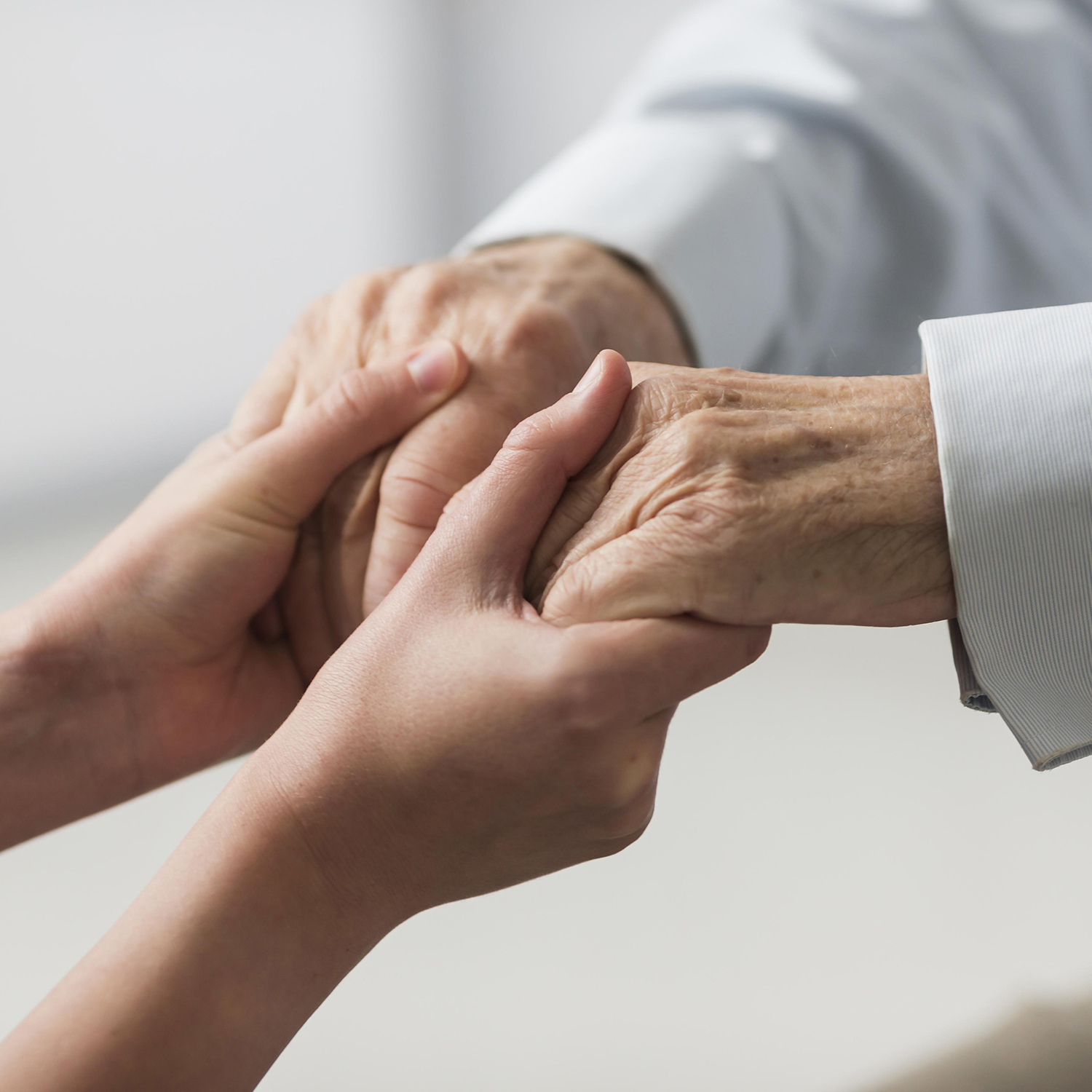 Person holding hands with an elderly individual